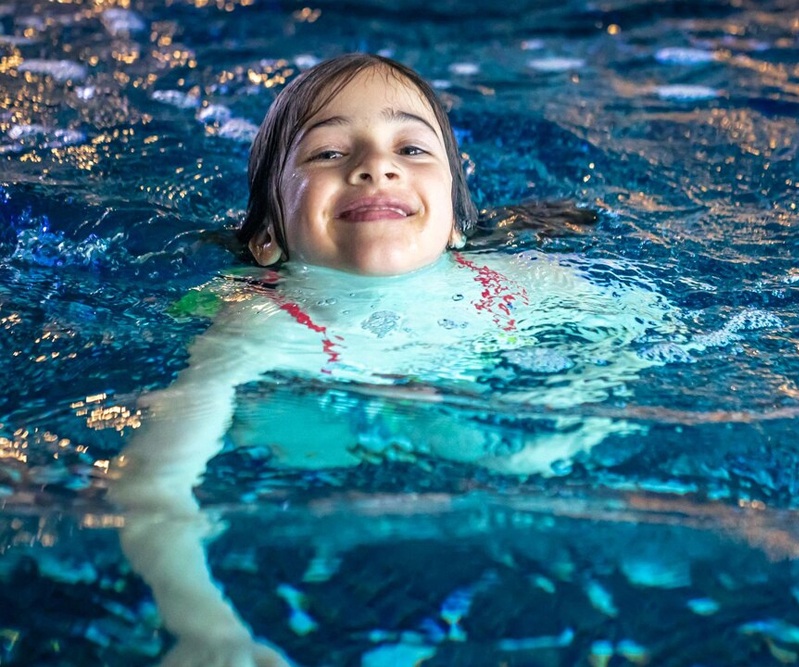 Young swimmer practising floating and water confidence.